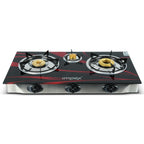 A three-burner gas stove with a glossy black glass front, accented with red graphic lines and gold burner caps. The brand name 'implex' is printed in white on the front.